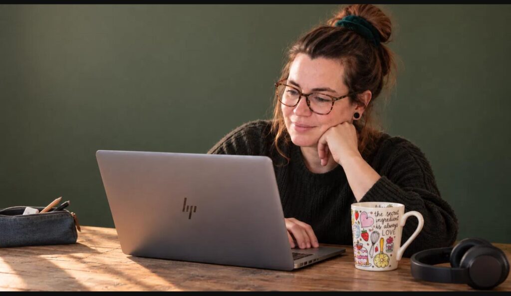 Hanna achter haar laptop met een kop koffie